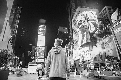 The advertising world is big and bright! Boy looking at electronic billboards.