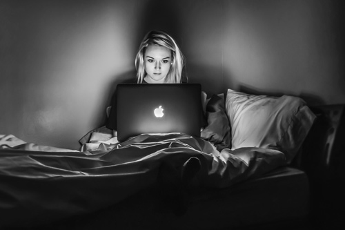 Woman sitting in bed with her laptop.